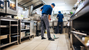 A team of restaurant cleaners cleaning a kitchen
